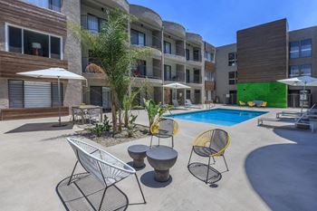 A pool area with a white chair and a yellow chair at Lafayette Apartments, California